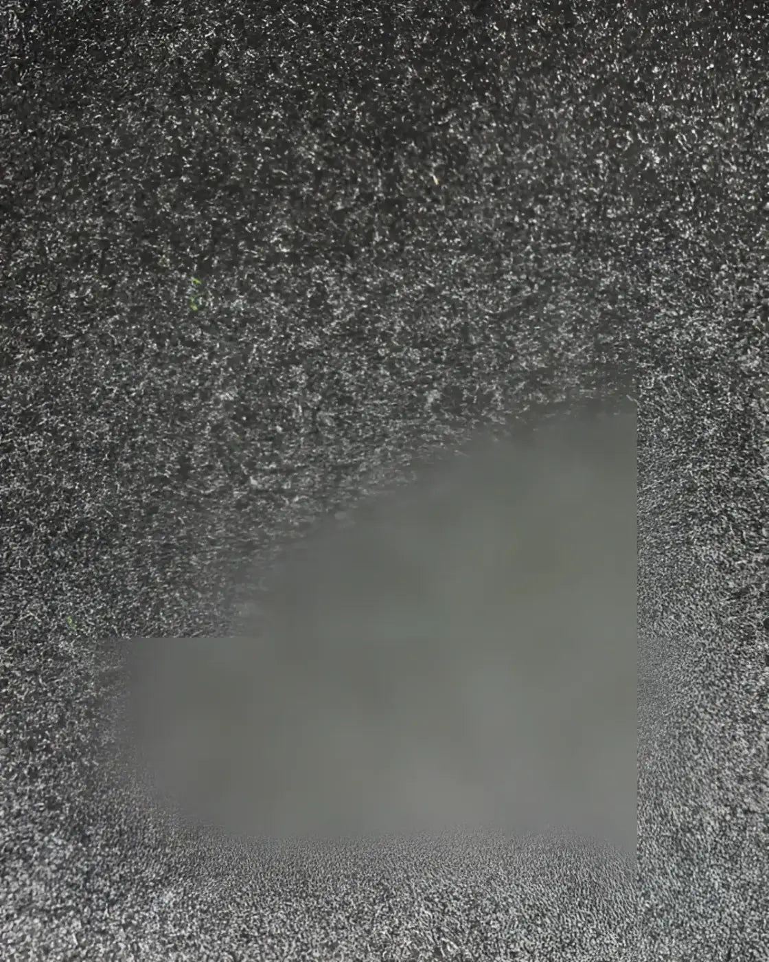 Grayscale grainy texture showing the back side of 30mm premium turf tile built for home use measuring 1m by 0.5m