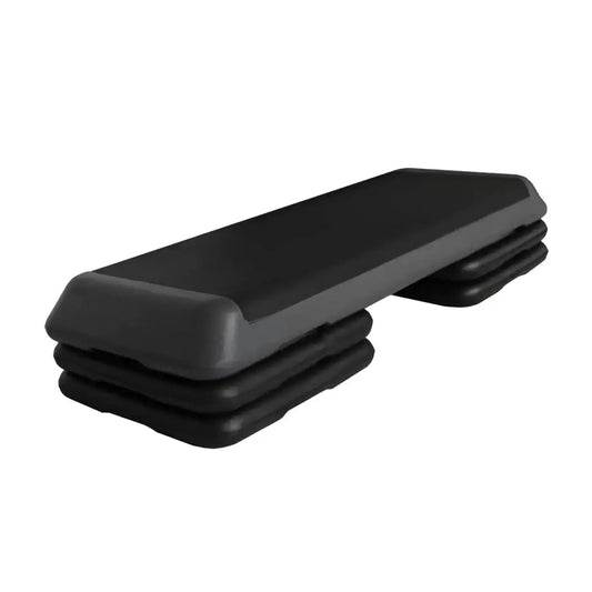 Black plastic aerobic step with textured non-slip surface and layered design for home workout use