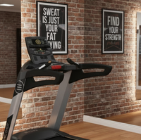 An Encore treadmill in a modern gym setting with a brick wall, mirrors, motivational posters, and other exercise equipment.