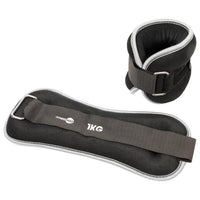 A pair of black adjustable weightlifting ankle cuffs and a matching black ankle pad with a grey strap, shown on a plain white background. 