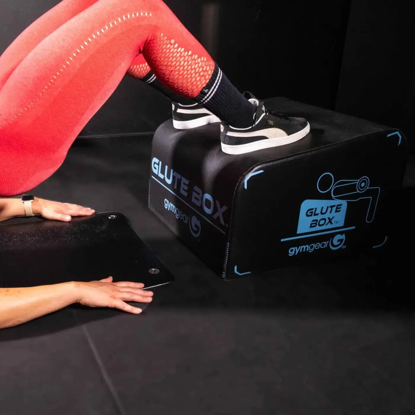 Gym gear angled glute box in black with blue branding and stylized figure graphic for home workout use