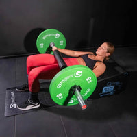 Green 10 kg gymgear weight plates on a barbell for strength training with gym gear angled glute box home workout