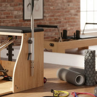 Wooden pilates reformer with black padded seat and metal adjustment mechanisms from gym gear wunda chair uk delivery