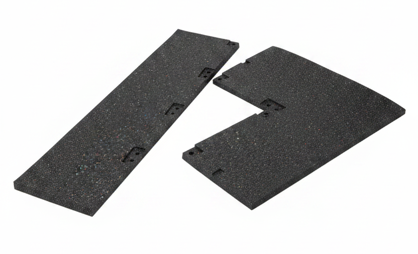 Two black textured rubber or foam panels with pre-drilled mounting holes, displayed on wooden pallets.