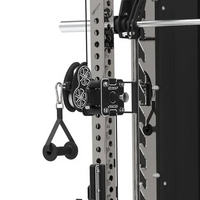 Close-up of a power rack attachment with a black cable pulley system and dual wheels, mounted on a silver and black strength training machine. The attachment features a black plate with silver hardware and a black handlebar pull tab.