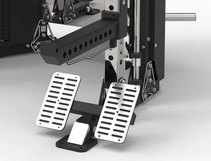 A close-up of a vehicle brake and accelerator pedal assembly with two silver metal slotted pedals on a black mounting base, shown against a clean light gray studio background.