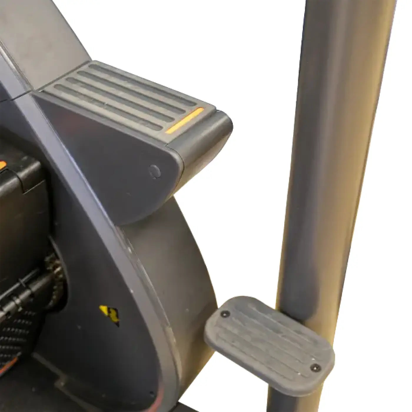 Gray plastic foot pedal with textured grip and screws attached to gym gear sc8 stair climber frame for home cardio use