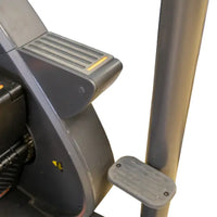 Gray plastic foot pedal with textured grip and screws attached to gym gear sc8 stair climber frame for home cardio use