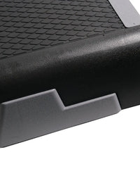 Black rubberized Gym Gear Studio aerobic step with textured diamond grip surface and reinforced side edges for home gym use