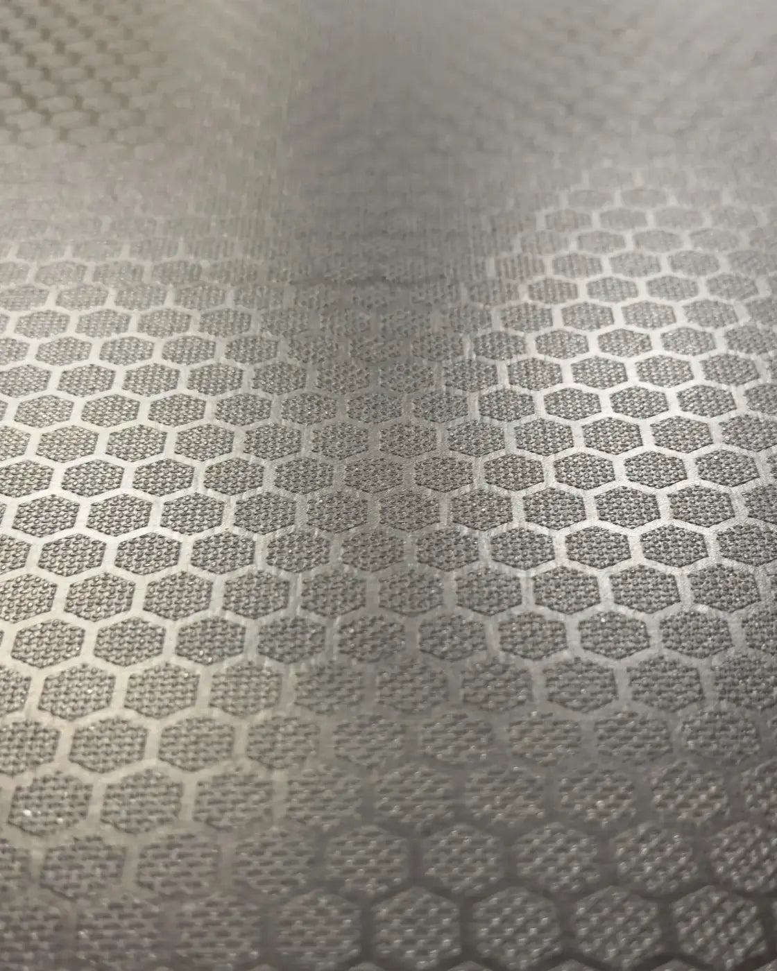 Silver metallic surface with a repeating hexagonal pattern on gym gear wooden plyometric box for home fitness use
