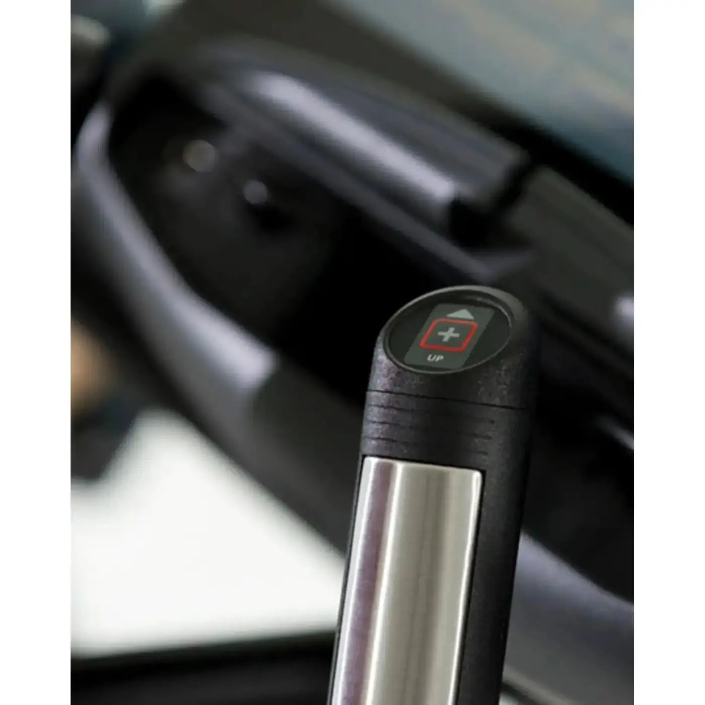 Black and silver handle of the Gym Gear X98e cross trainer featuring a circular button with a red plus sign