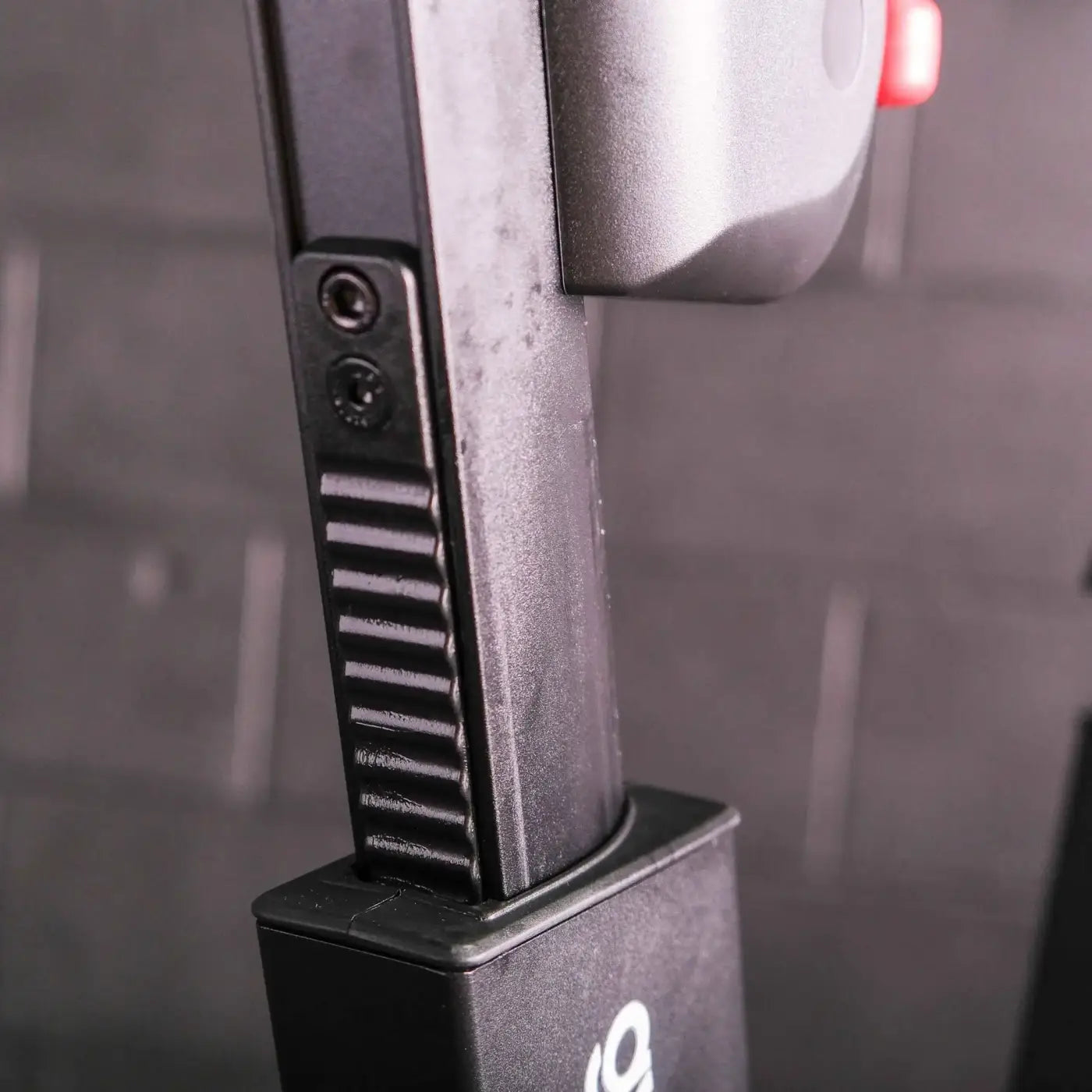 Black textured grip with screws and ridges mounted on a matching black base of m sport elite upright exercise bike rear side