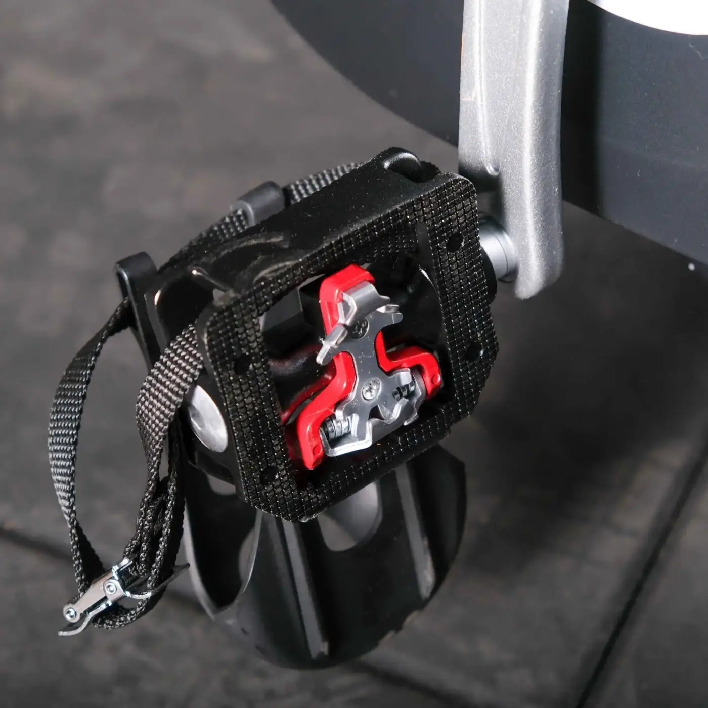Black cycling pedal with red and silver cleat mechanism on msport elite upright exercise bike for home gym uk