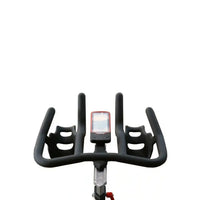 M sport pro indoor exercise bike with black ergonomic handlebars, integrated cup holders, and digital display on silver stem